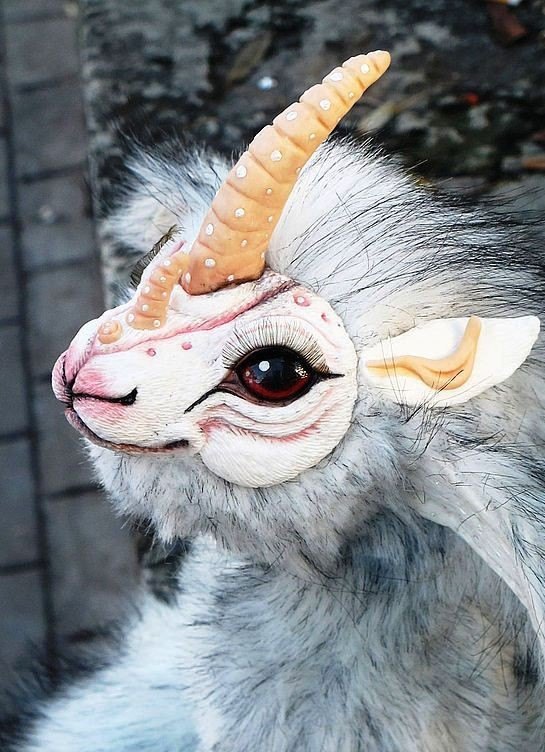 Фантастическое существо, игрушка-единорог ручной работы: длинный ребристый рог, красные глаза, серо-белый мех