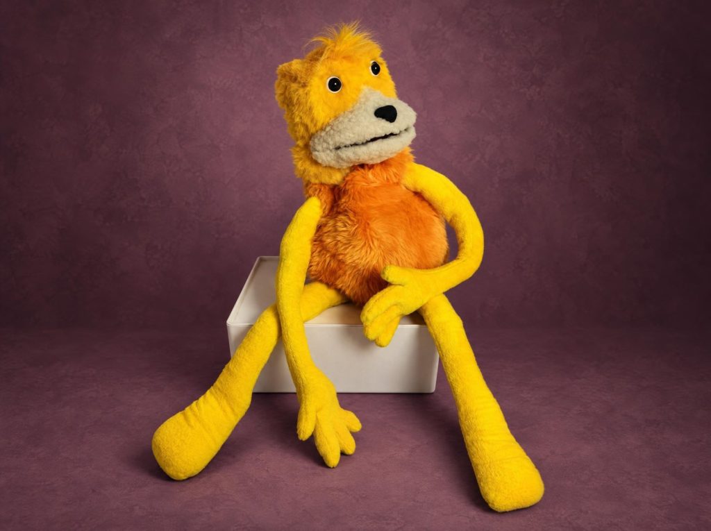 Flat Eric свесил длинные желтые ноги с белой коробки, сшить игрушку на заказ можно любого размера